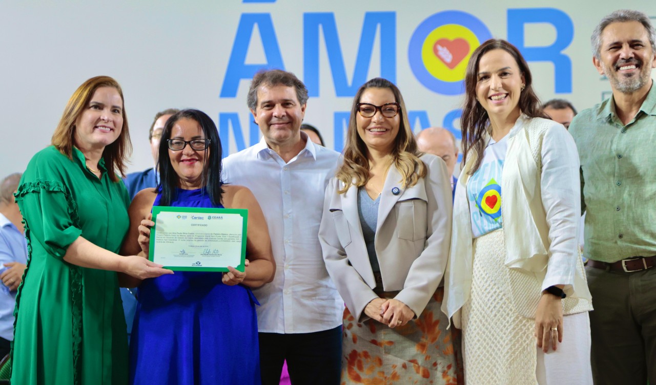 grupo de pessoas posa para a foto no palco do centro de eventos